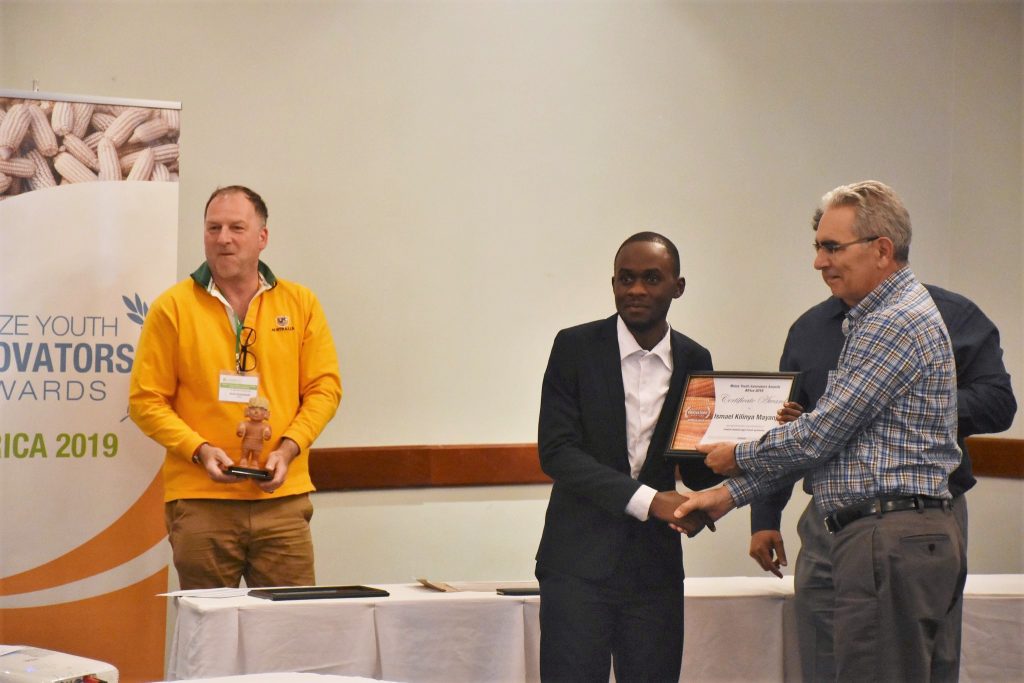 Ismael Mayanja (center) receives the 2019 MAIZE Youth Innovators Award  Africa at an award ceremony held in Lusaka, Zambia May 9, 2019. Photo: Jerome Bossuet.